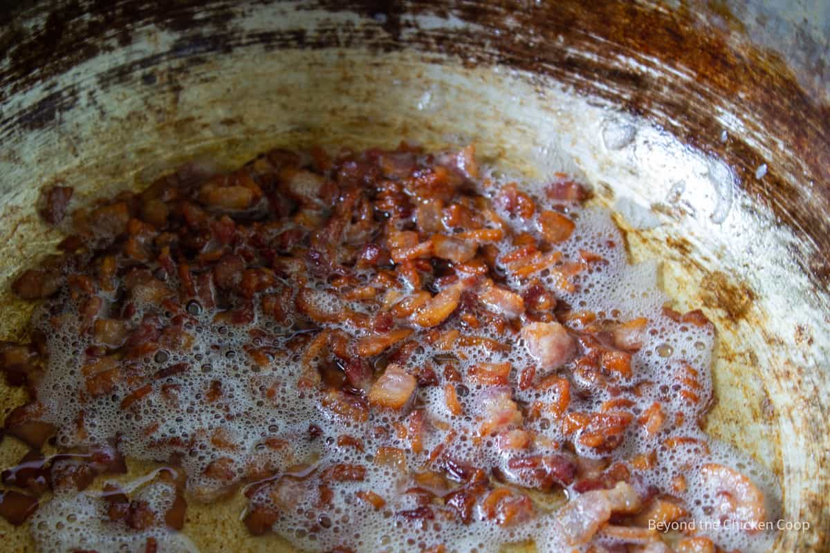 Bacon cooking in a pot.