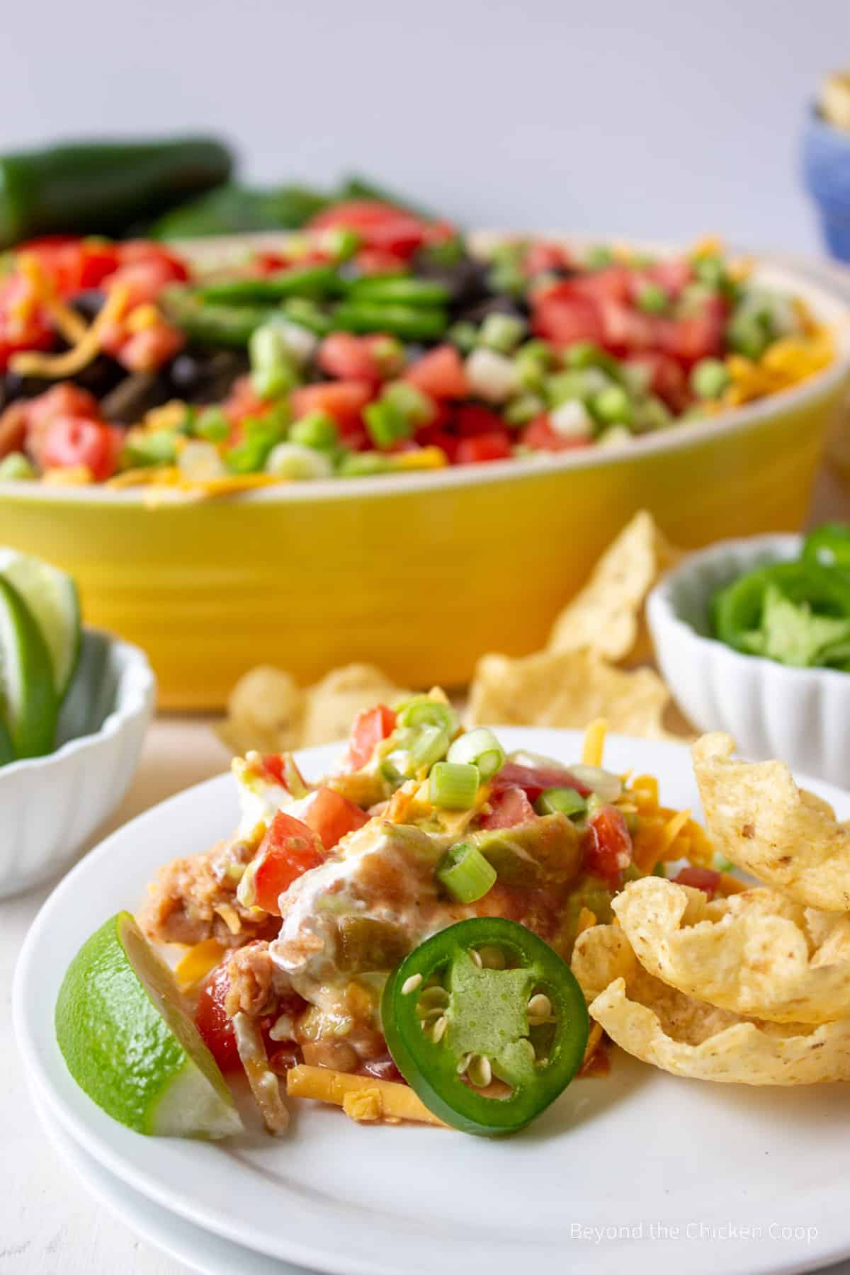 A layered bean dip with jalapenos and chips.