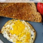 A breakfast plate with egg, toast and fruit.