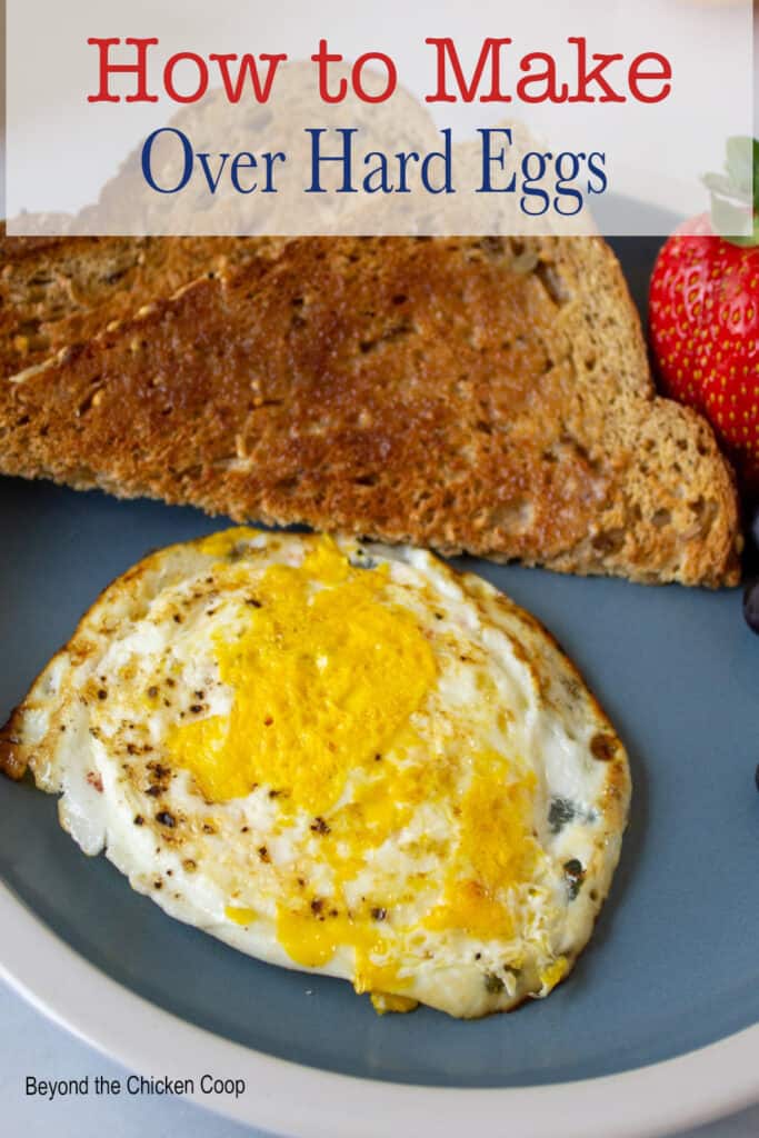 A breakfast plate with egg, toast and fruit.