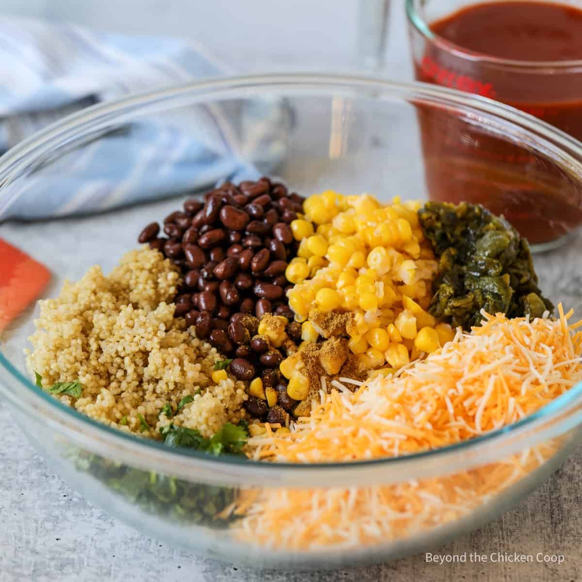 Beans, corn, quinoa and cheese in a large mixing bowl.