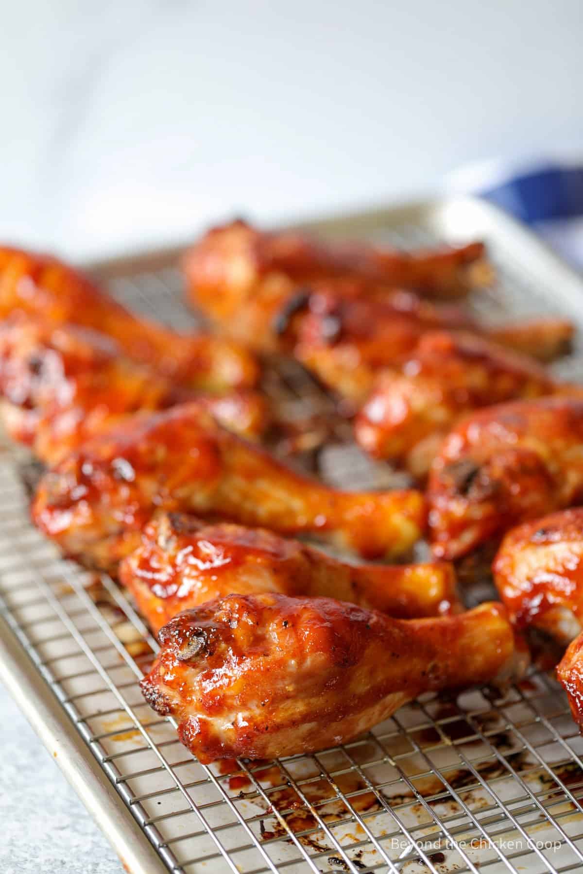 Cooked chicken legs on a baking rack.