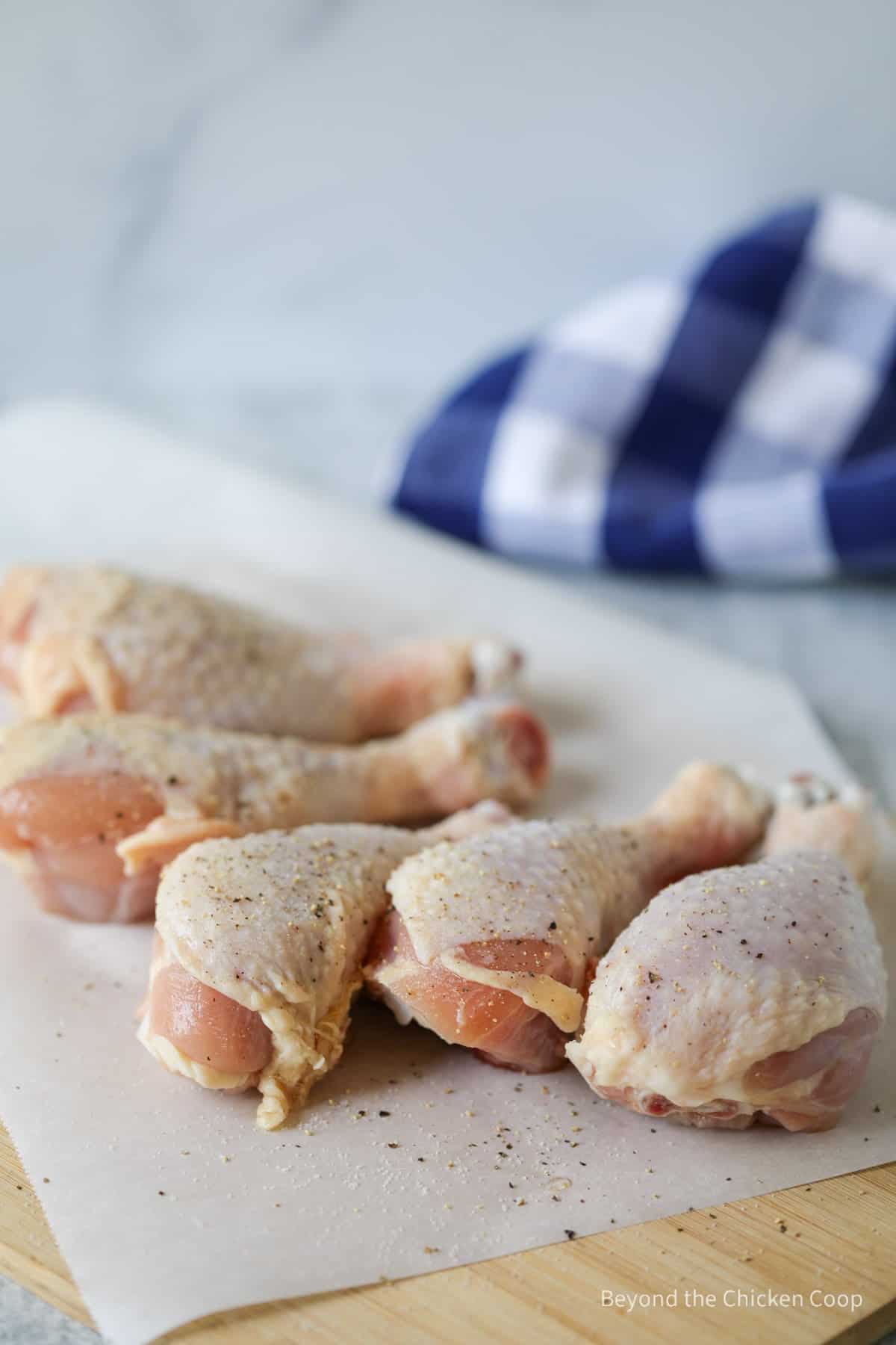 Adding seasoning to chicken legs.