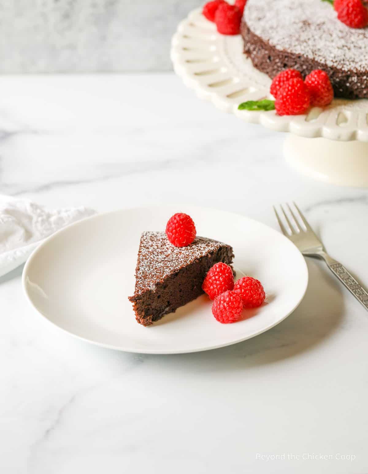 A slice of chocolate cake with raspberries.