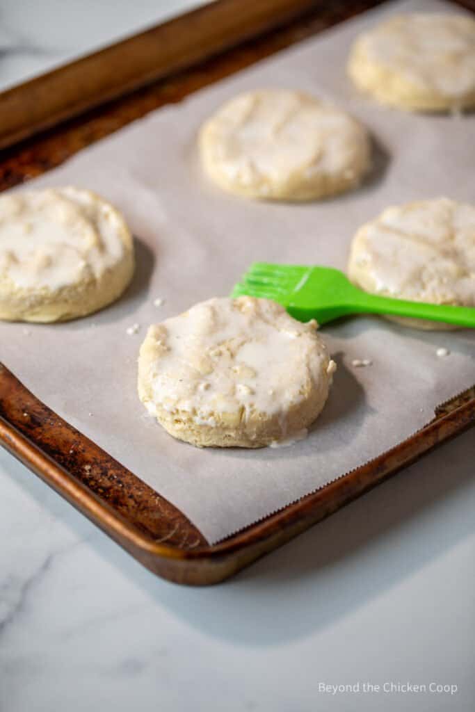 Brushing cream onto biscuits.