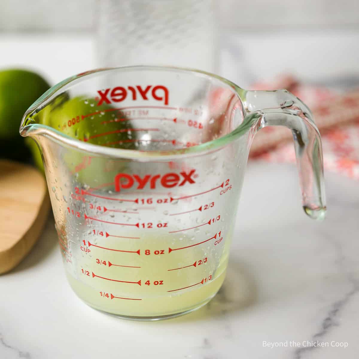 A measuring cup with lime juice.
