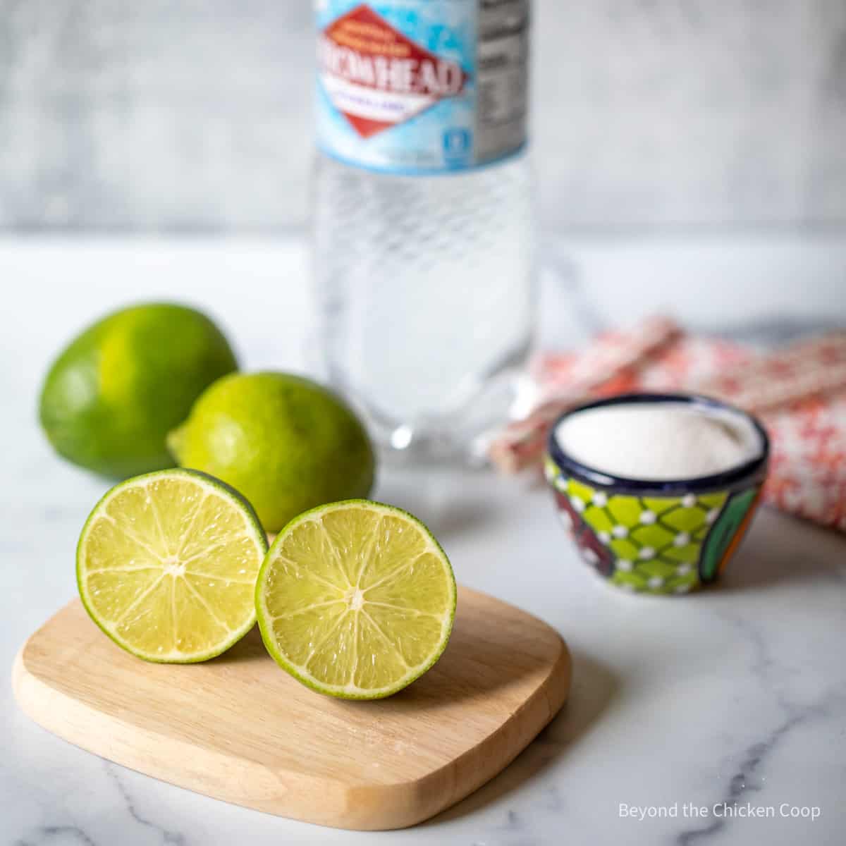 Fresh limes, sugar and a bottle of sparkling water.