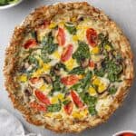 A quiche with tomatoes and spinach.