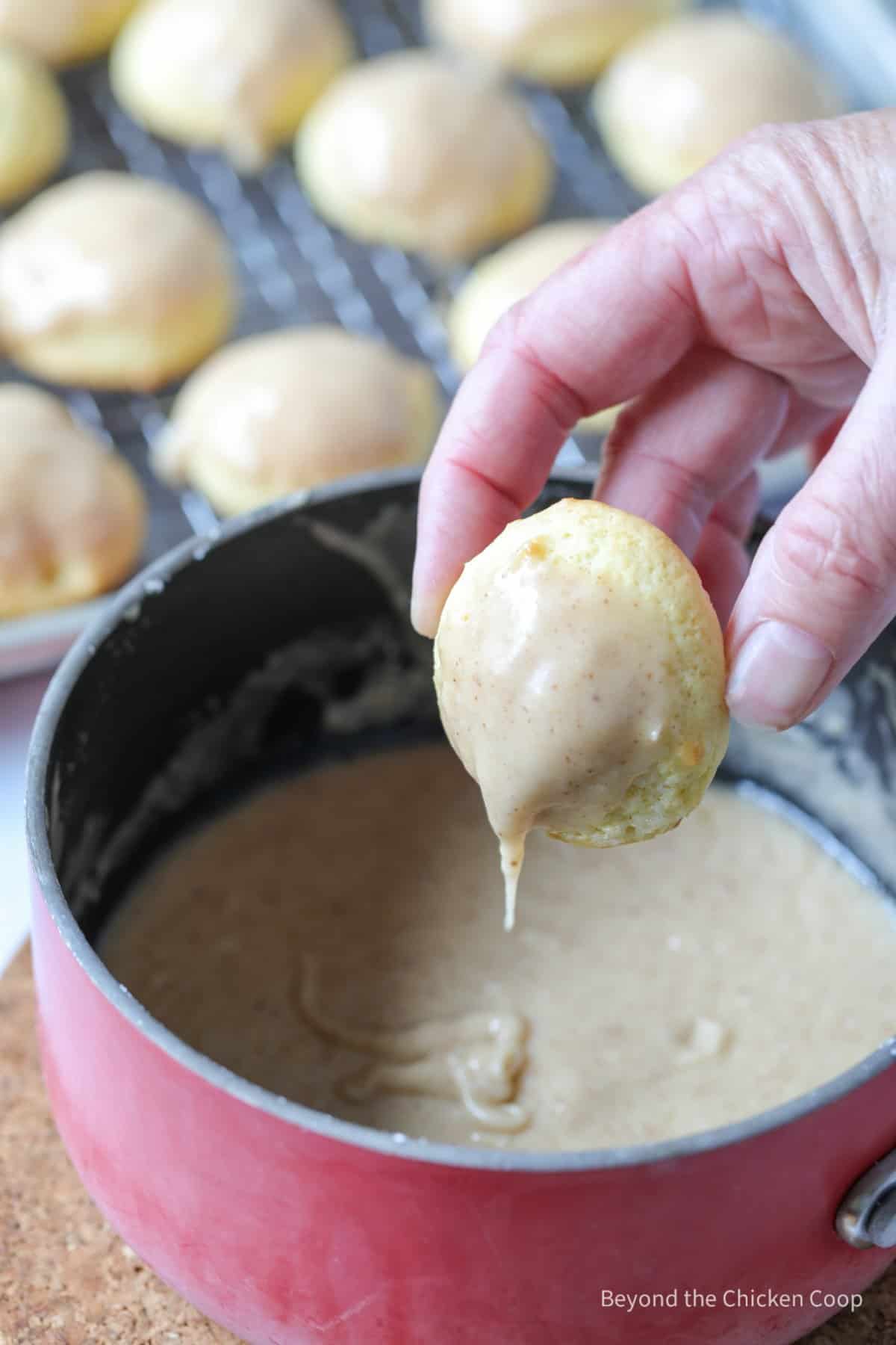 Pulling a cookie out of the dipping glaze.