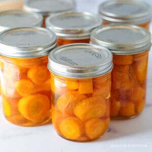 Canning jars filled with chopped carrots.