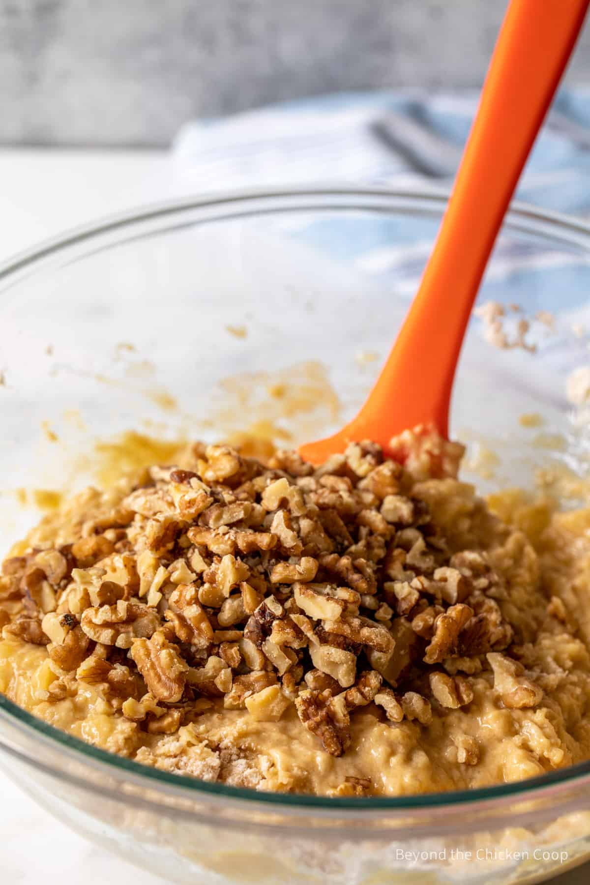 Stirring walnuts into muffin batter.