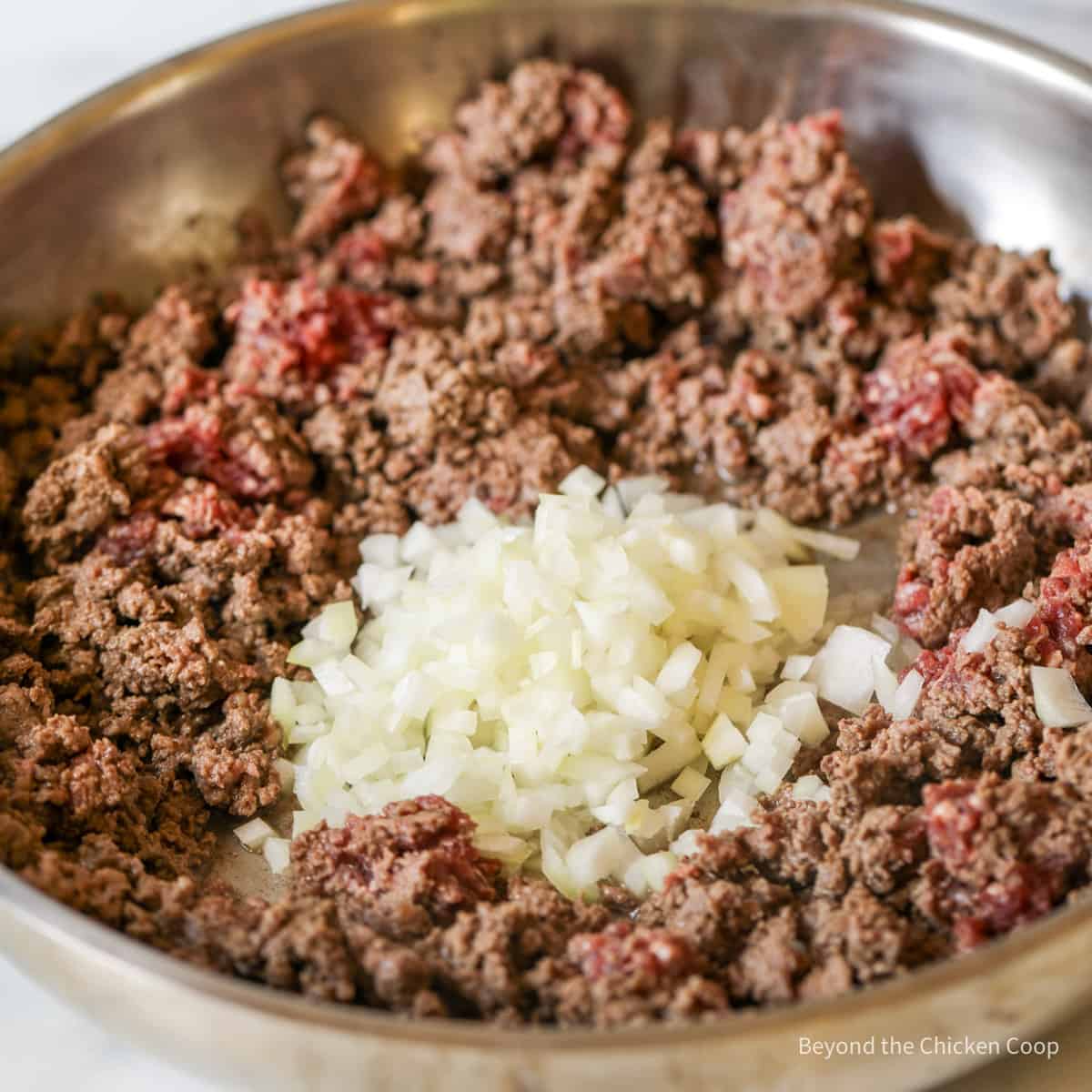 Ground beef and onions in a pan.