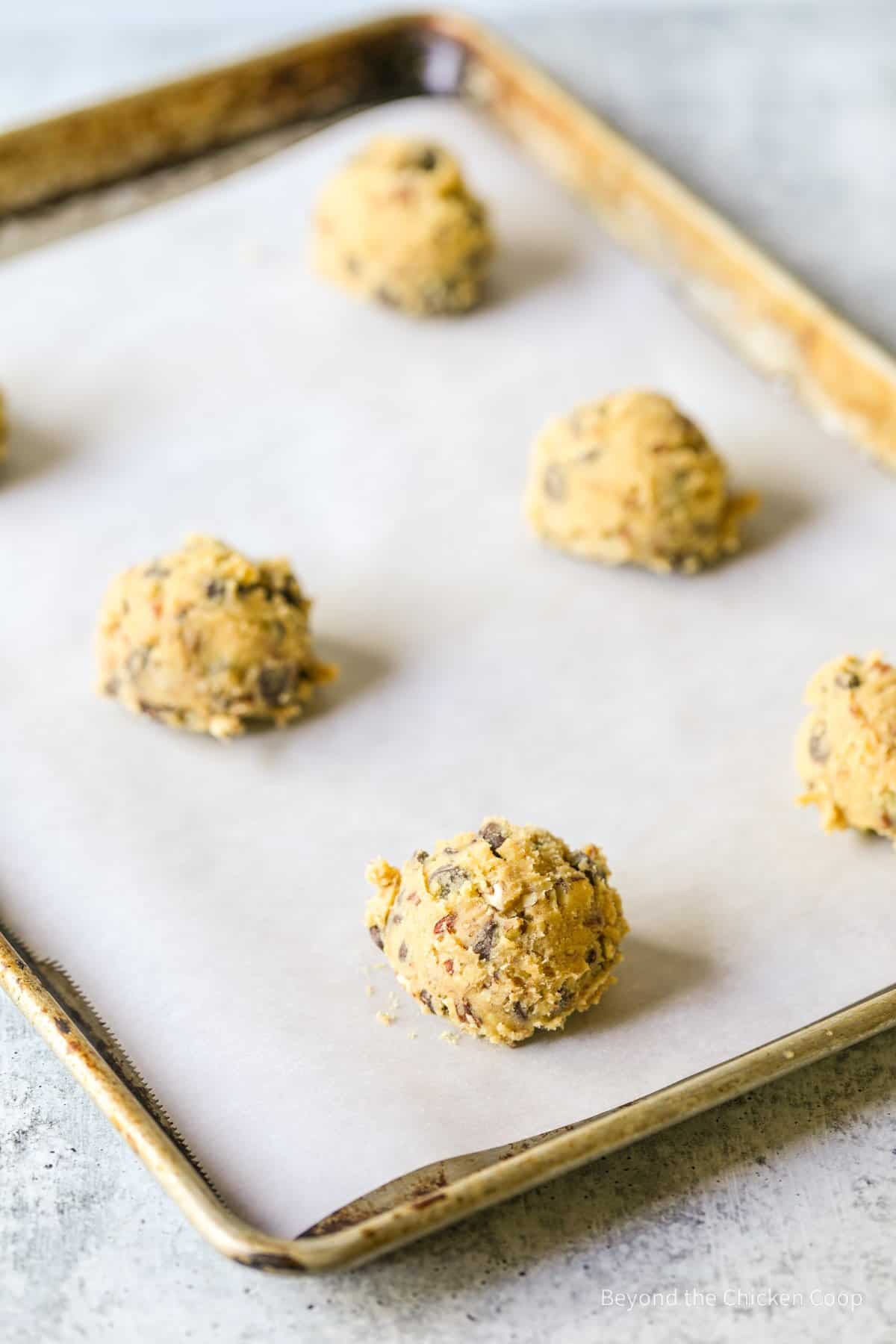 Scoops of cookie dough on a baking sheet.