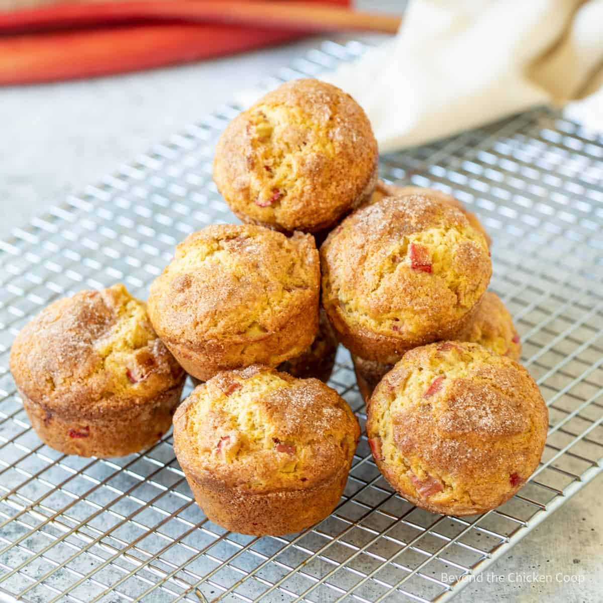 Rhubarb muffins on a baking rack.