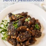 Cooked mushrooms on a plate with sprigs of thyme.