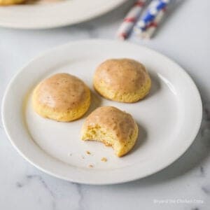 Three cookies with frosting on a plate.