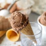 A scoop of chocolate ice cream in a sugar cone.
