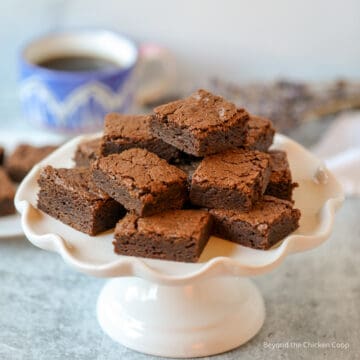 A white cake stand filled with brownies.