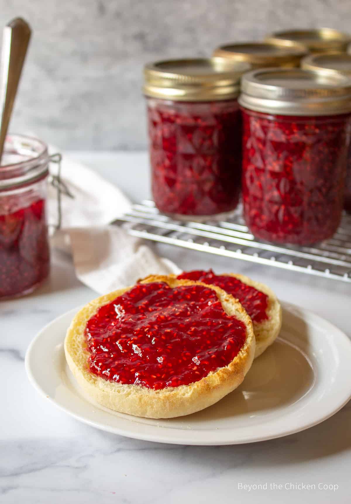 Two english muffins topped with raspberry jam.