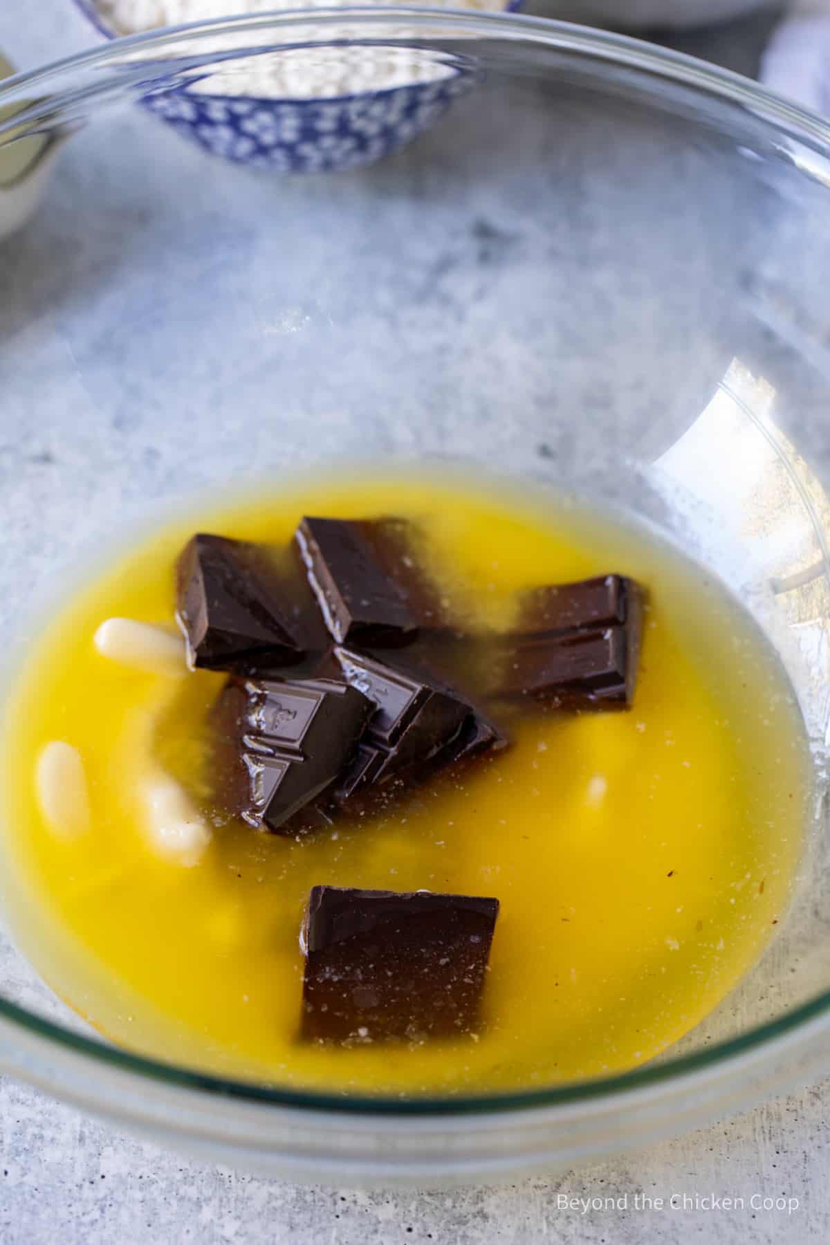 Melted butter with chunks of chocolate in a bowl.