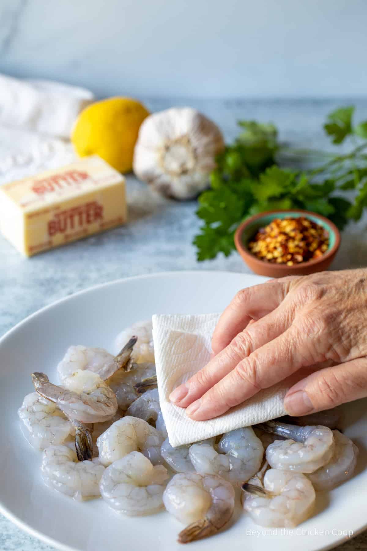 Patting shrimp with a paper towel.