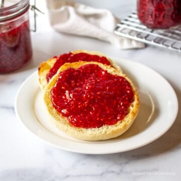 Toasted English muffin topped with raspberry jam.