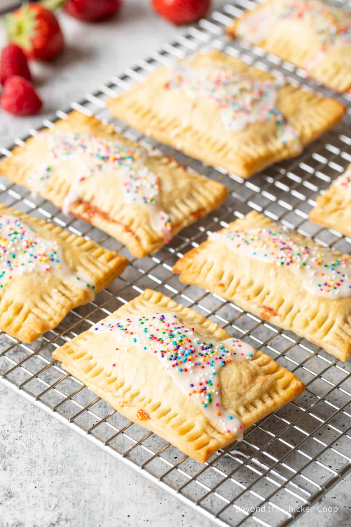 Pop tarts with colored sprinkles on a baking rack.