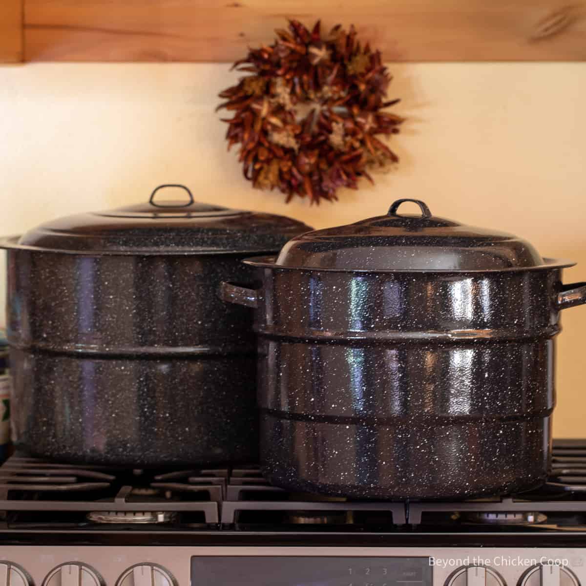 Two large canning pots on a stovetop.