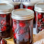 Pint sized canning jars filled with red cherries.