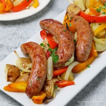 Italian sausages on top of onions, peppers and potatoes.