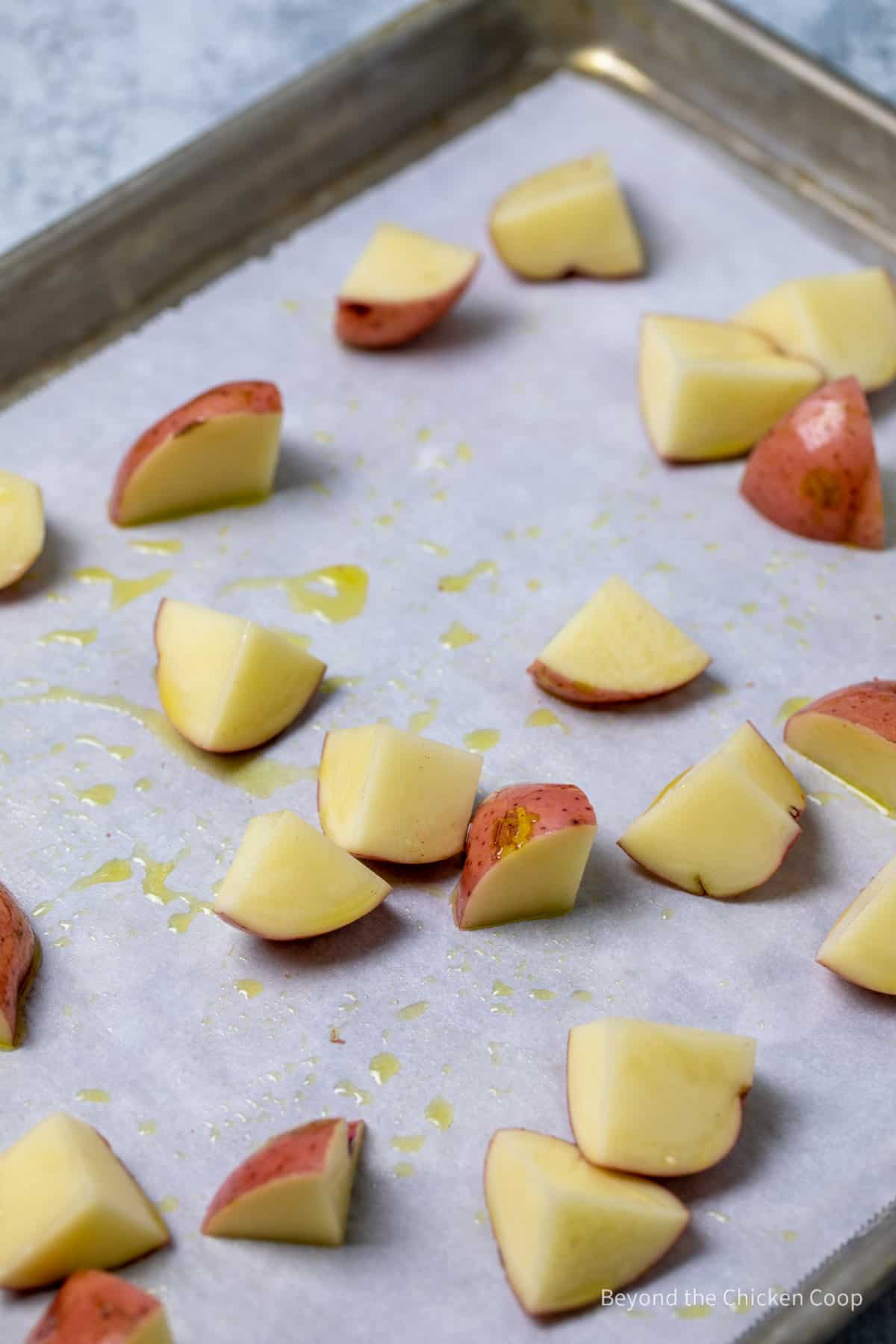 Cubed potatoes on a baking sheet.