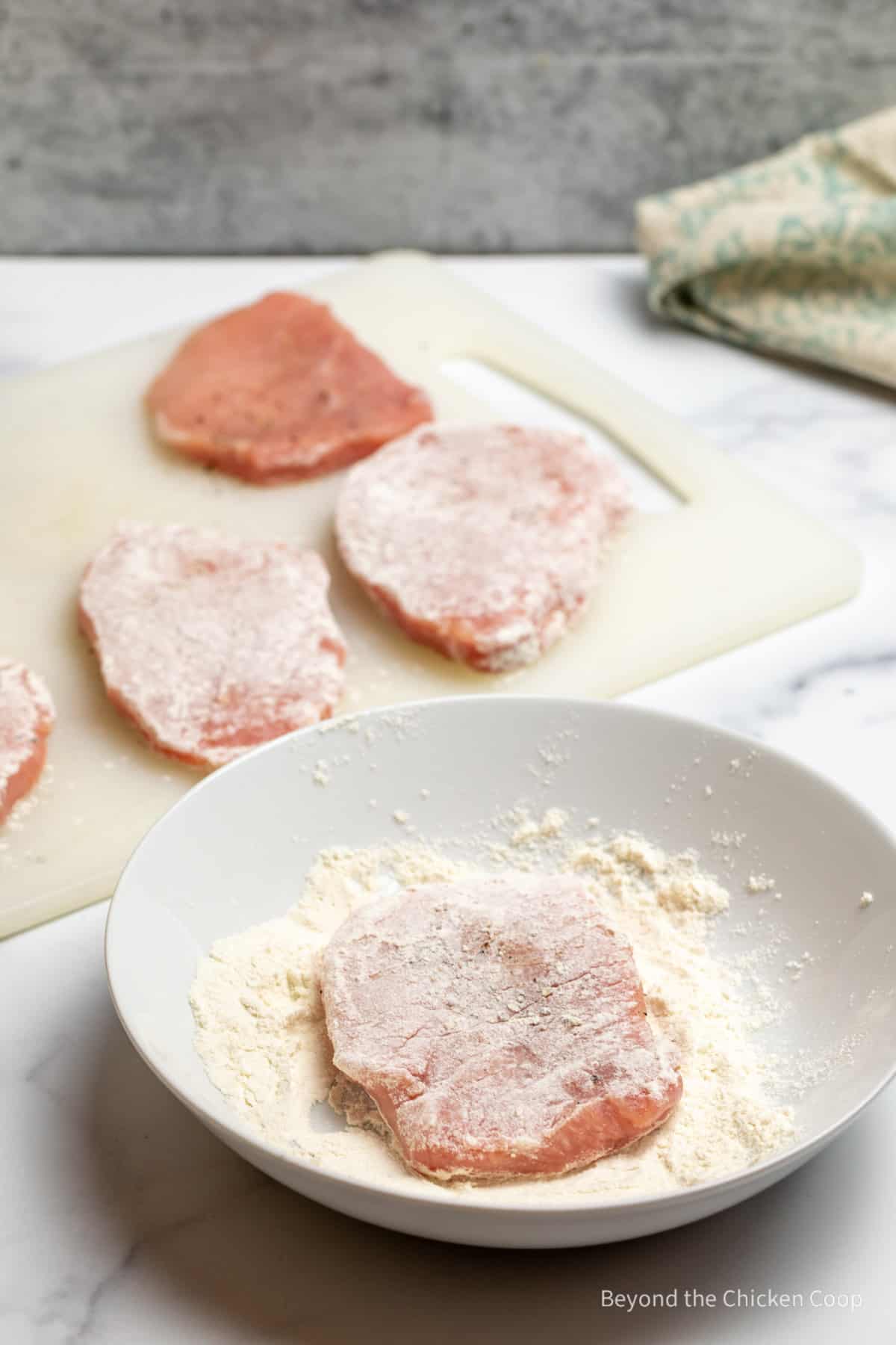 Dredging pork loin in flour. 