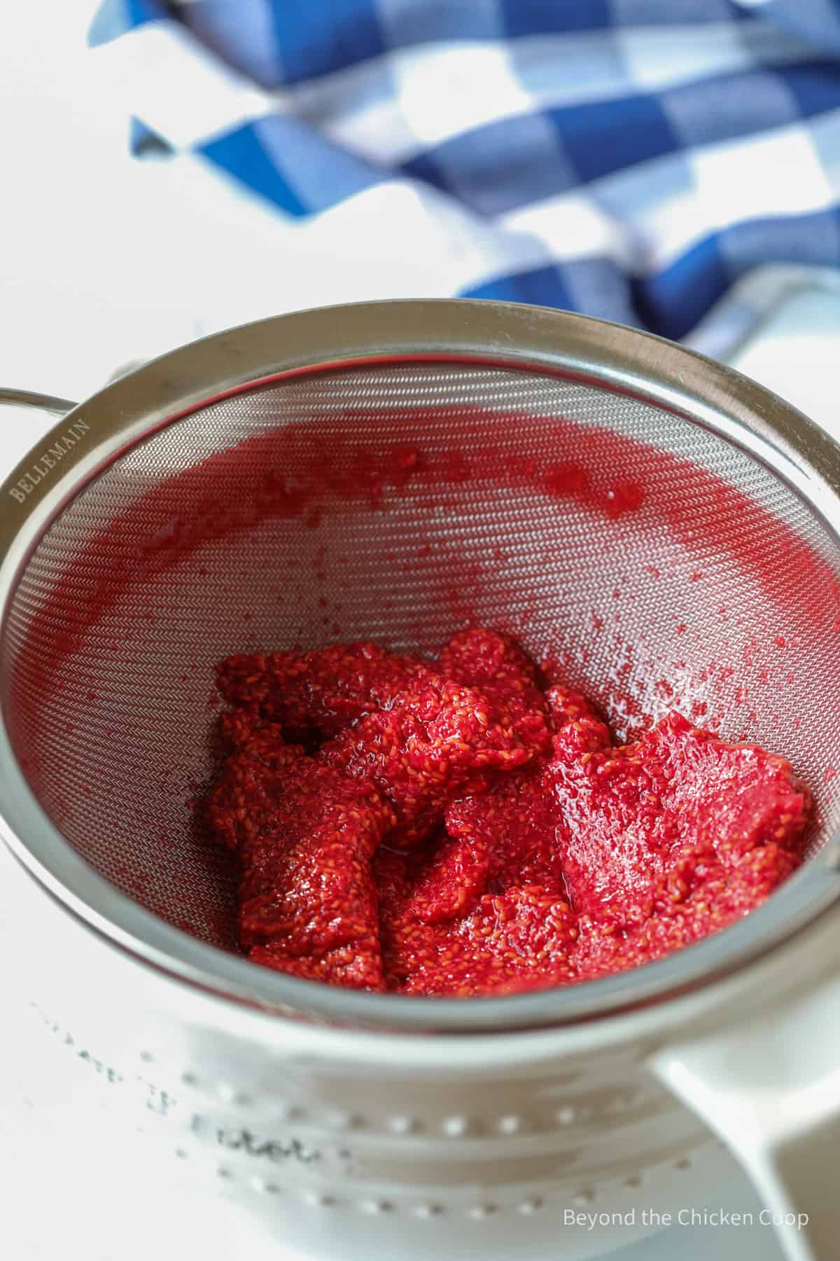 Strained raspberry sauce with the seeds left behind in the sieve.