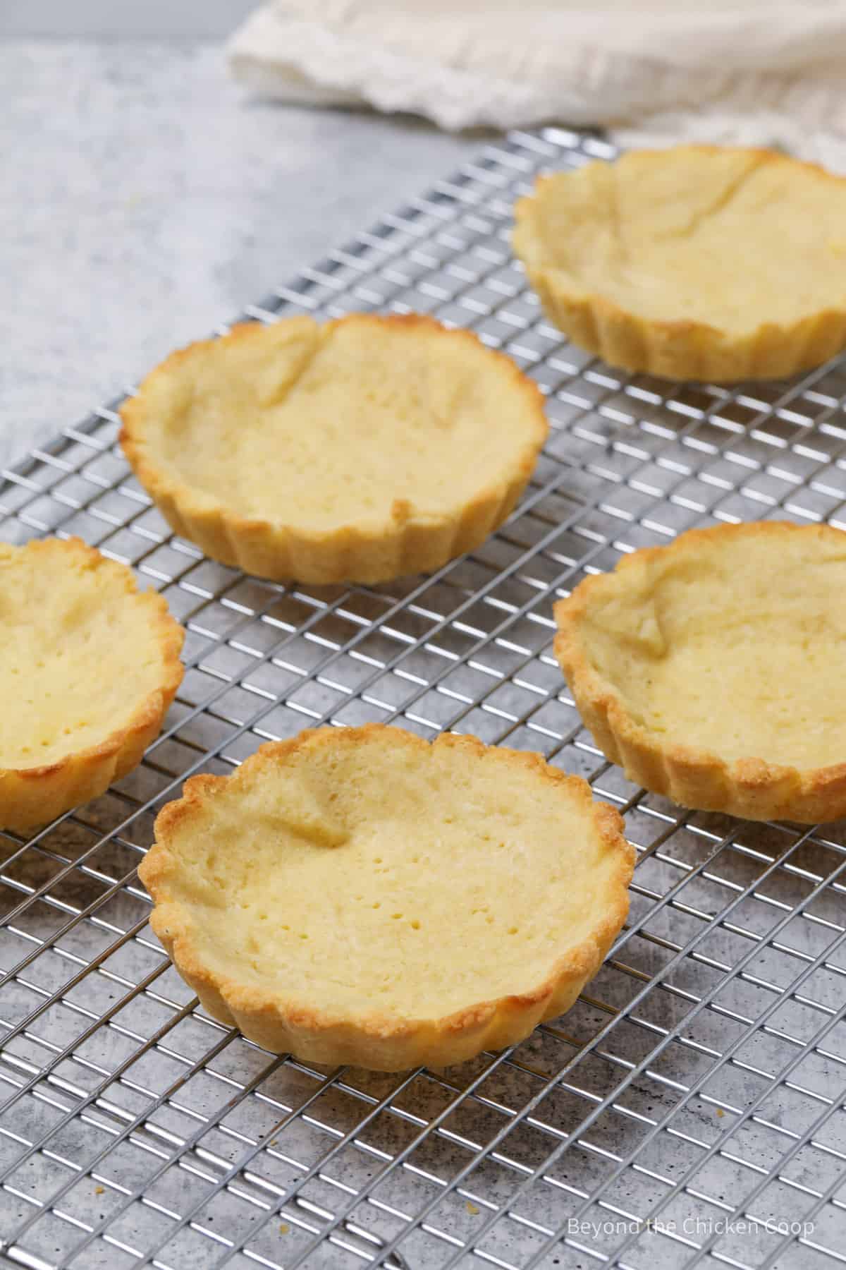 Baked tart shells on a cooling rack. 