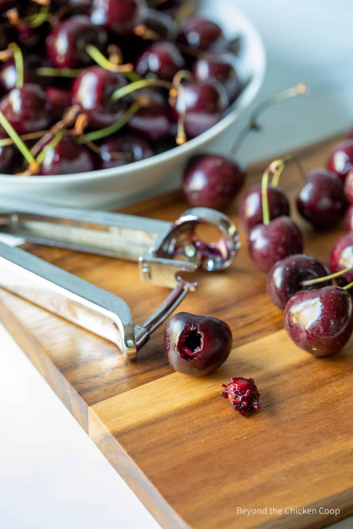 Removing a seed from a cherry using a cherry pitter.