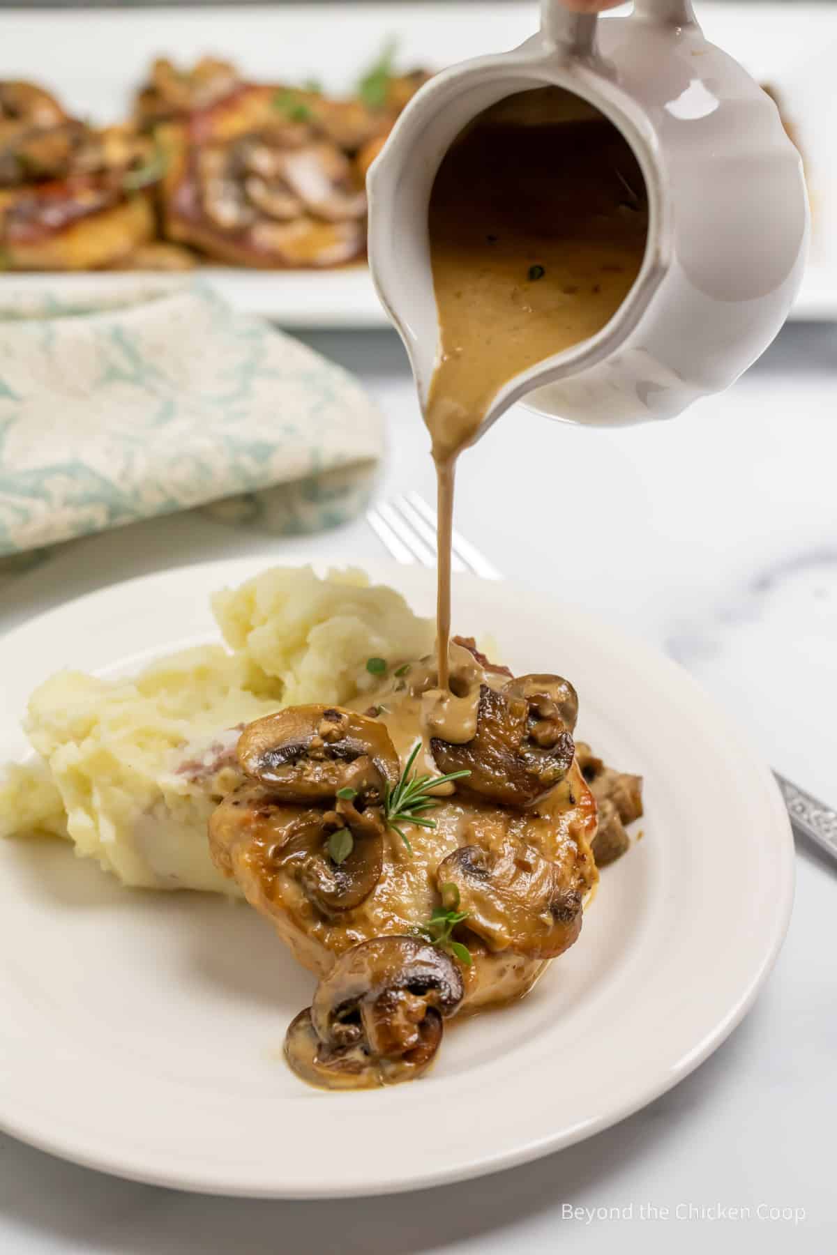 Pouring a sauce over pork with mushrooms.