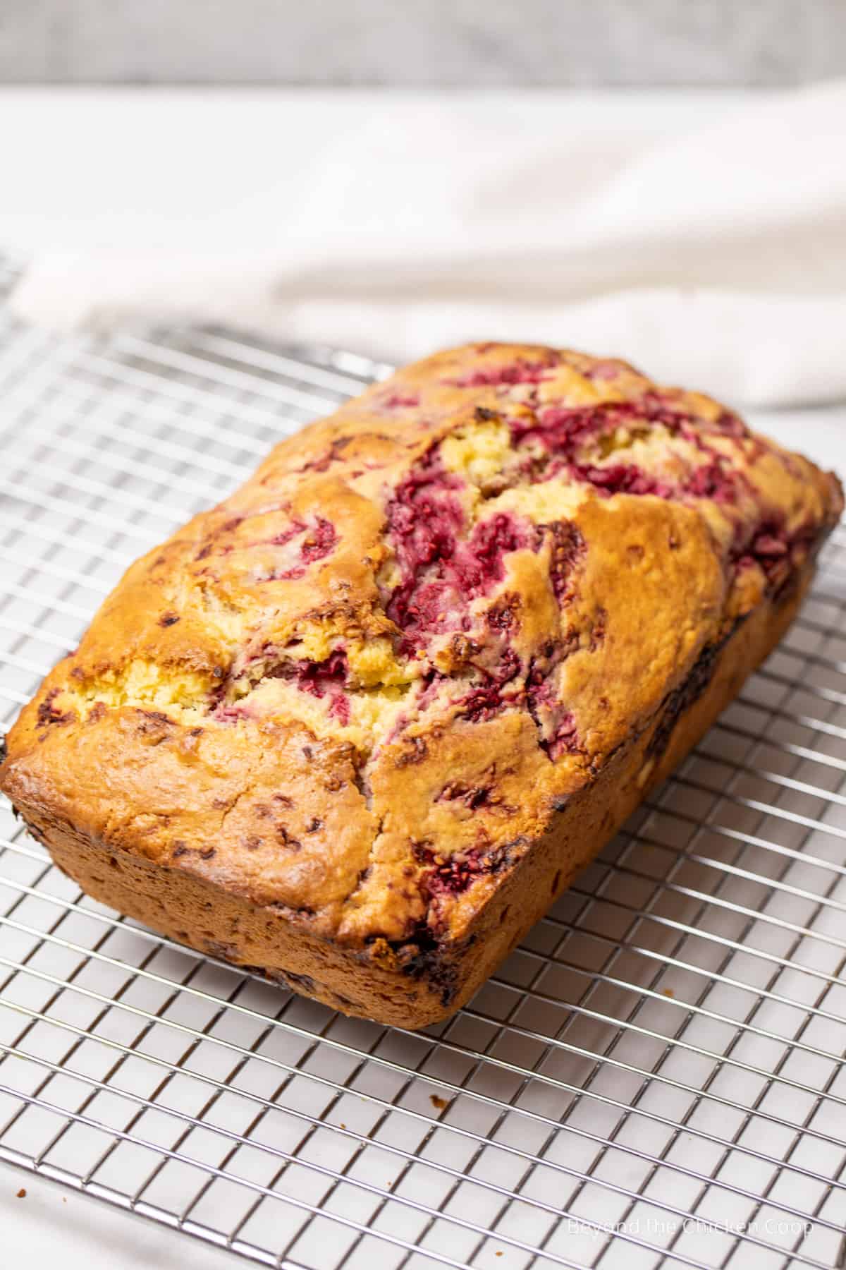 A baked loaf of bread on a cooling rack.