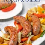 A platter filled with sliced peppers and onions and topped with Italian sausages.