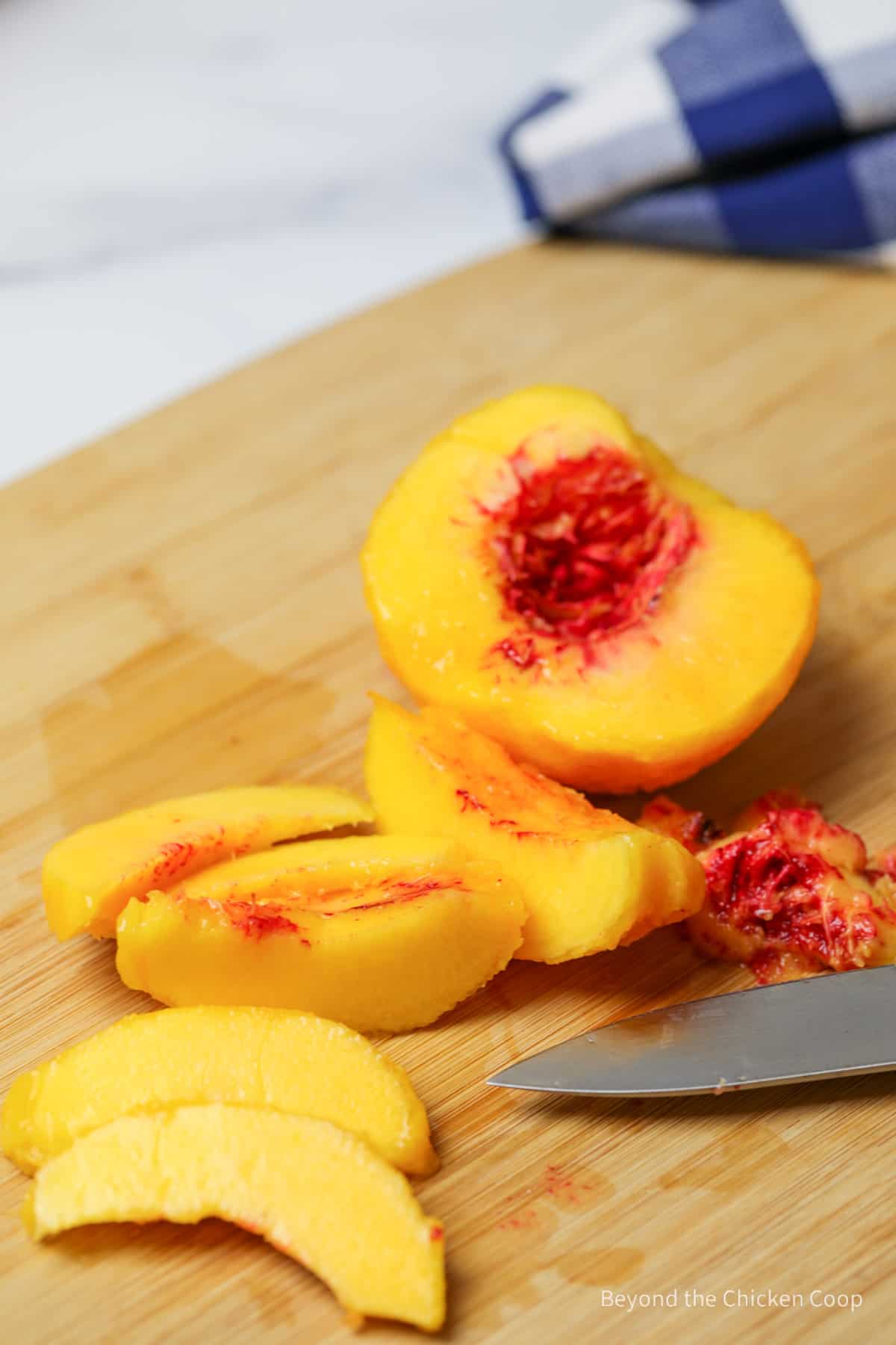 Sliced peach on a cutting board.