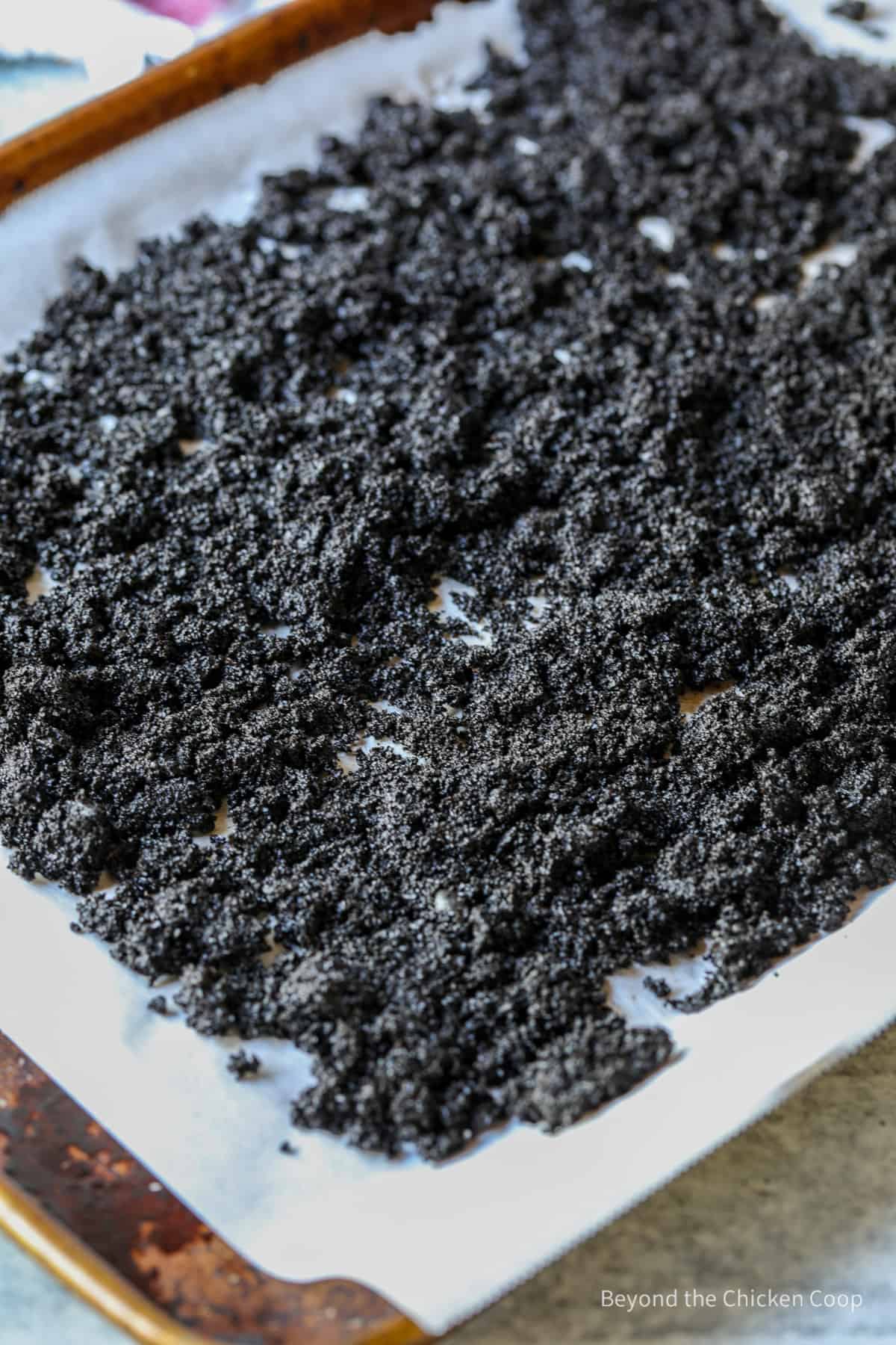 Wet coffee grounds on a baking sheet.