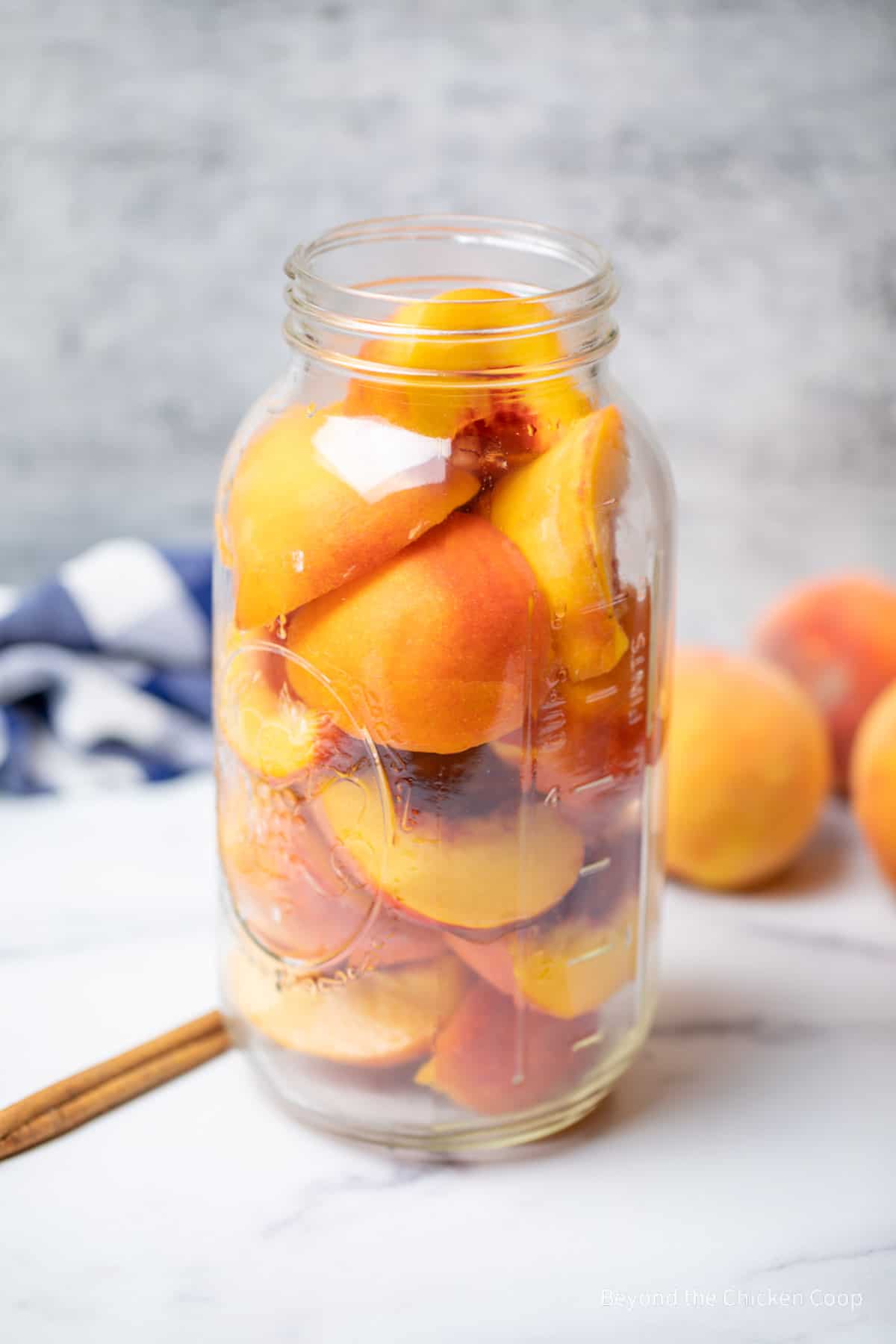 Peaches in a large glass container. 