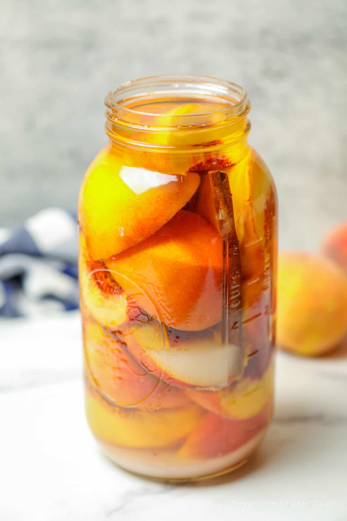 A large glass jar filled with peaches.