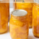 Jars filled with sliced peaches in a pie filling.
