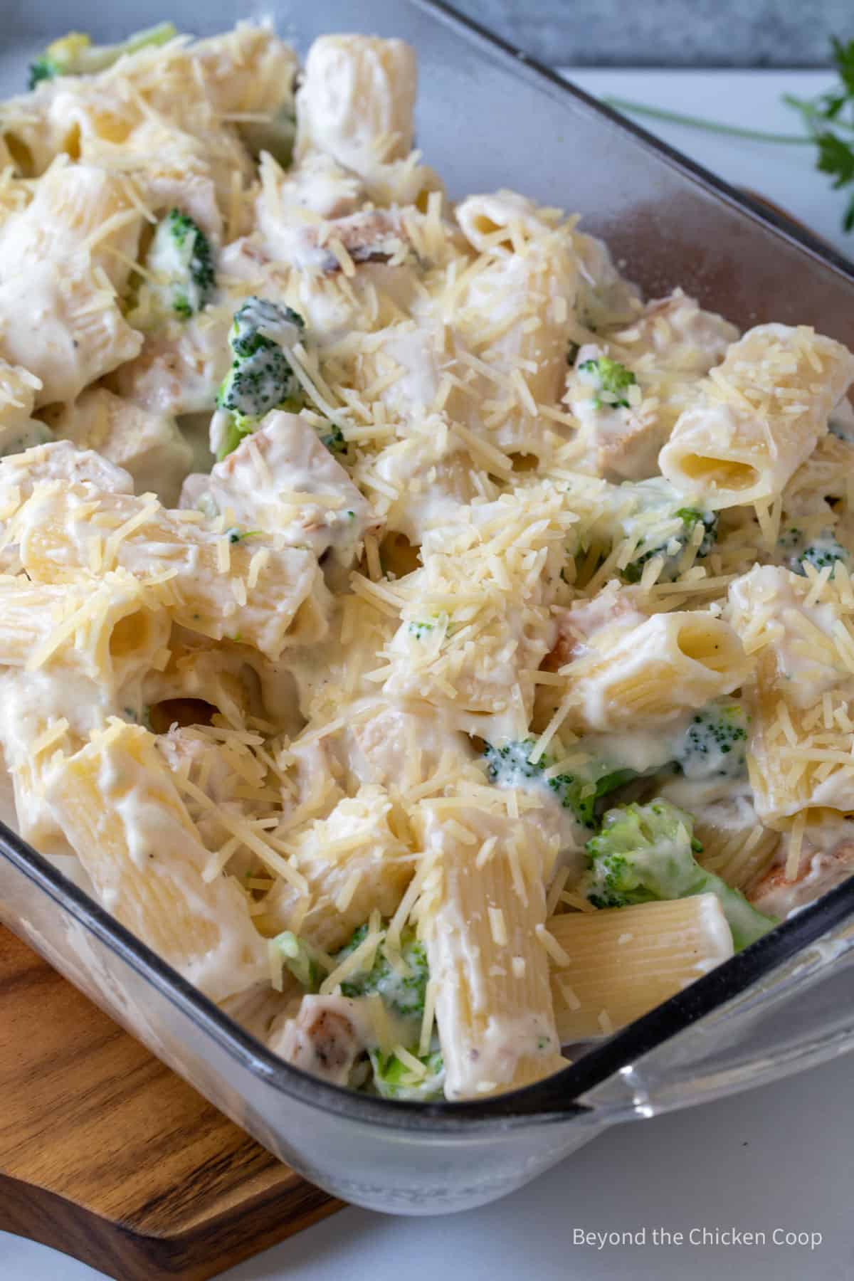 An unbaked chicken casserole in a glass dish.