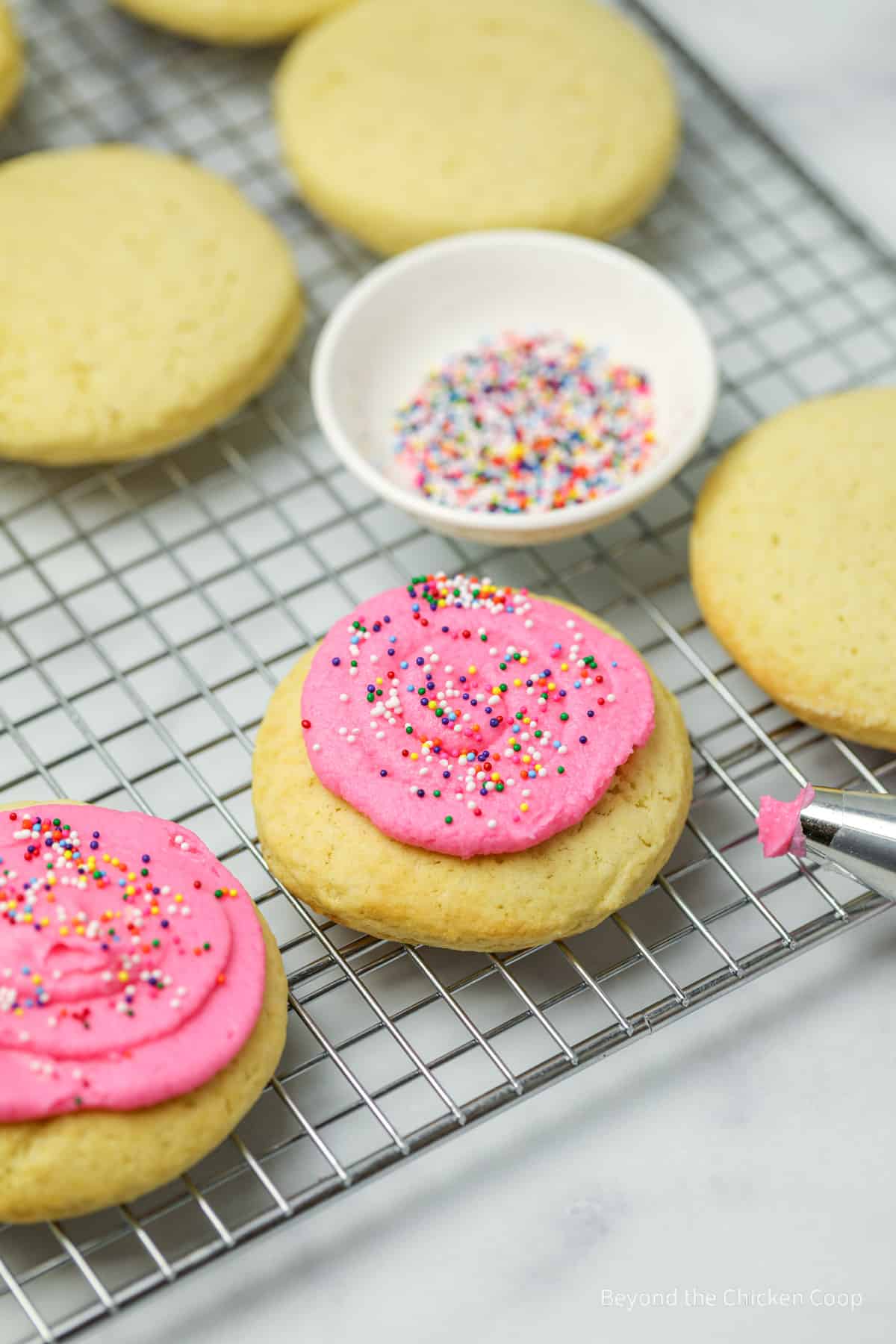 Frosting cookies with pink frosting.