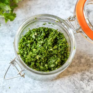 Chopped gremolata in a glass jar.