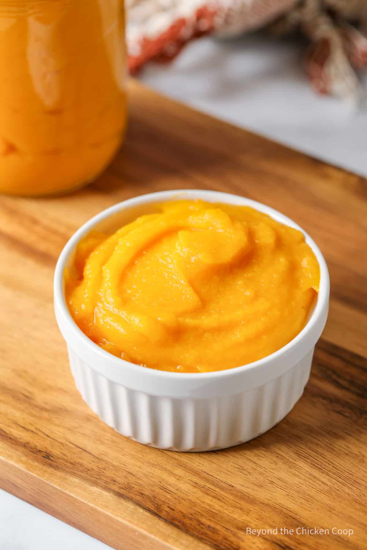 A small bowl filled with pureed pumkin.