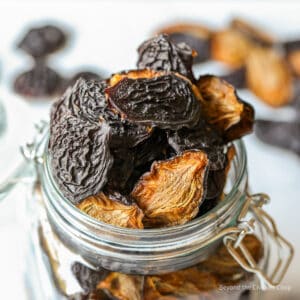 A glass crock filled with dried prunes.