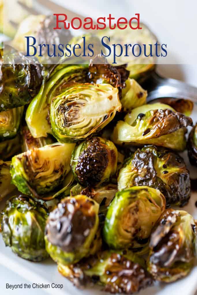 Brussels sprouts with a glaze on a white platter.
