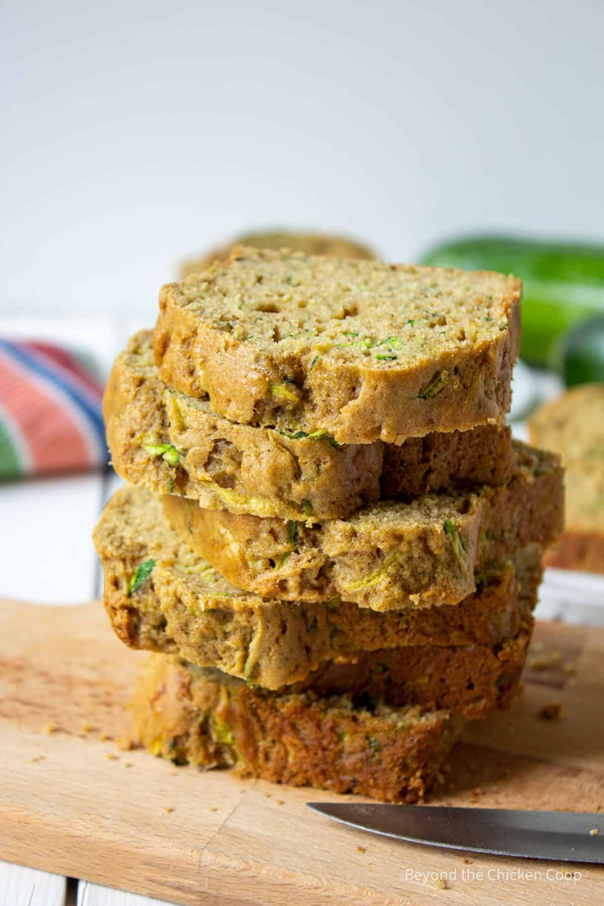 Slices of zucchini bread stacked on a board.